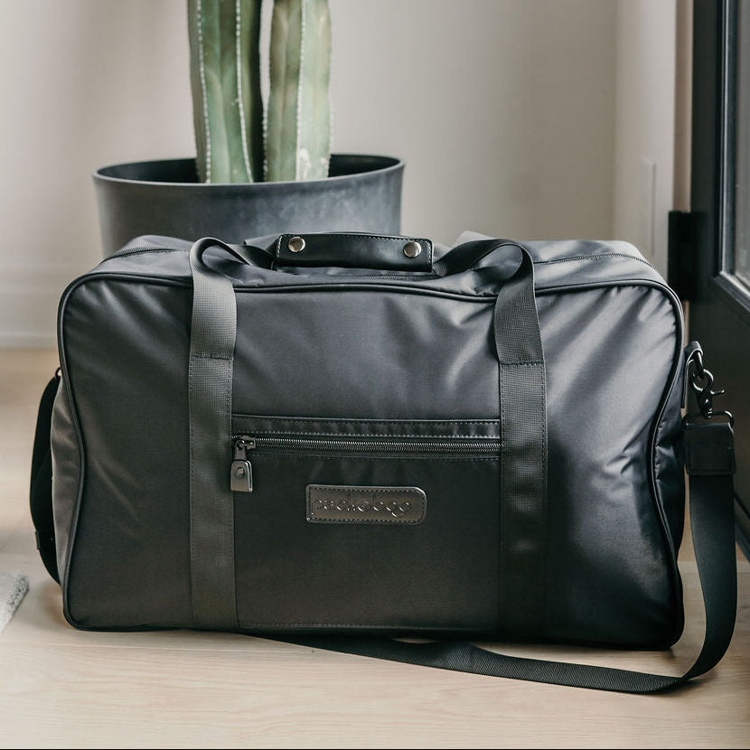 Black duffel bag with a cactus plant on a windowsill